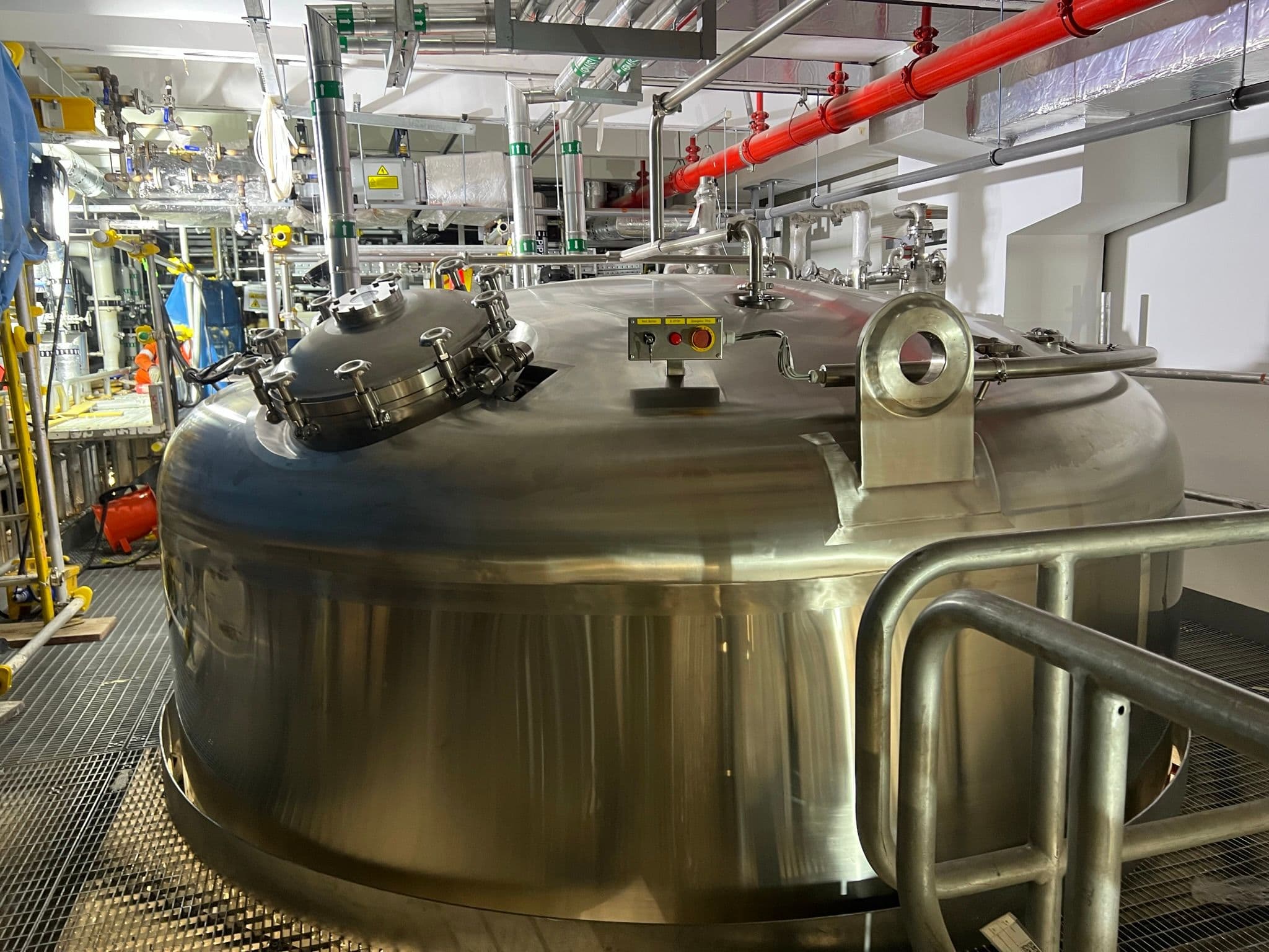 Stainless-steel process vessel with hygienic piping and instruments in a clean-utilities plantroom.