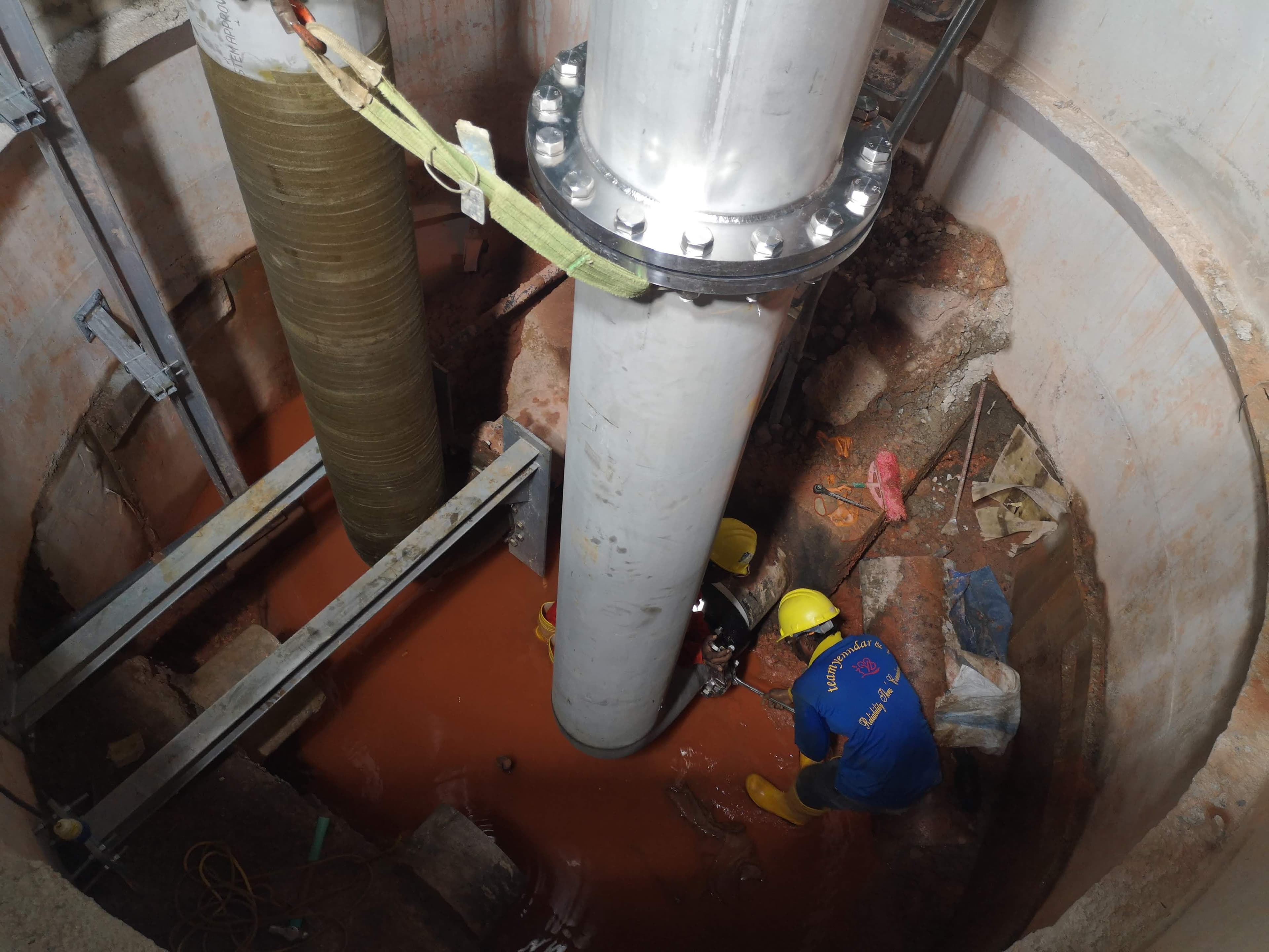 Worker carrying out a pipe tie-in inside an existing utility shaft.