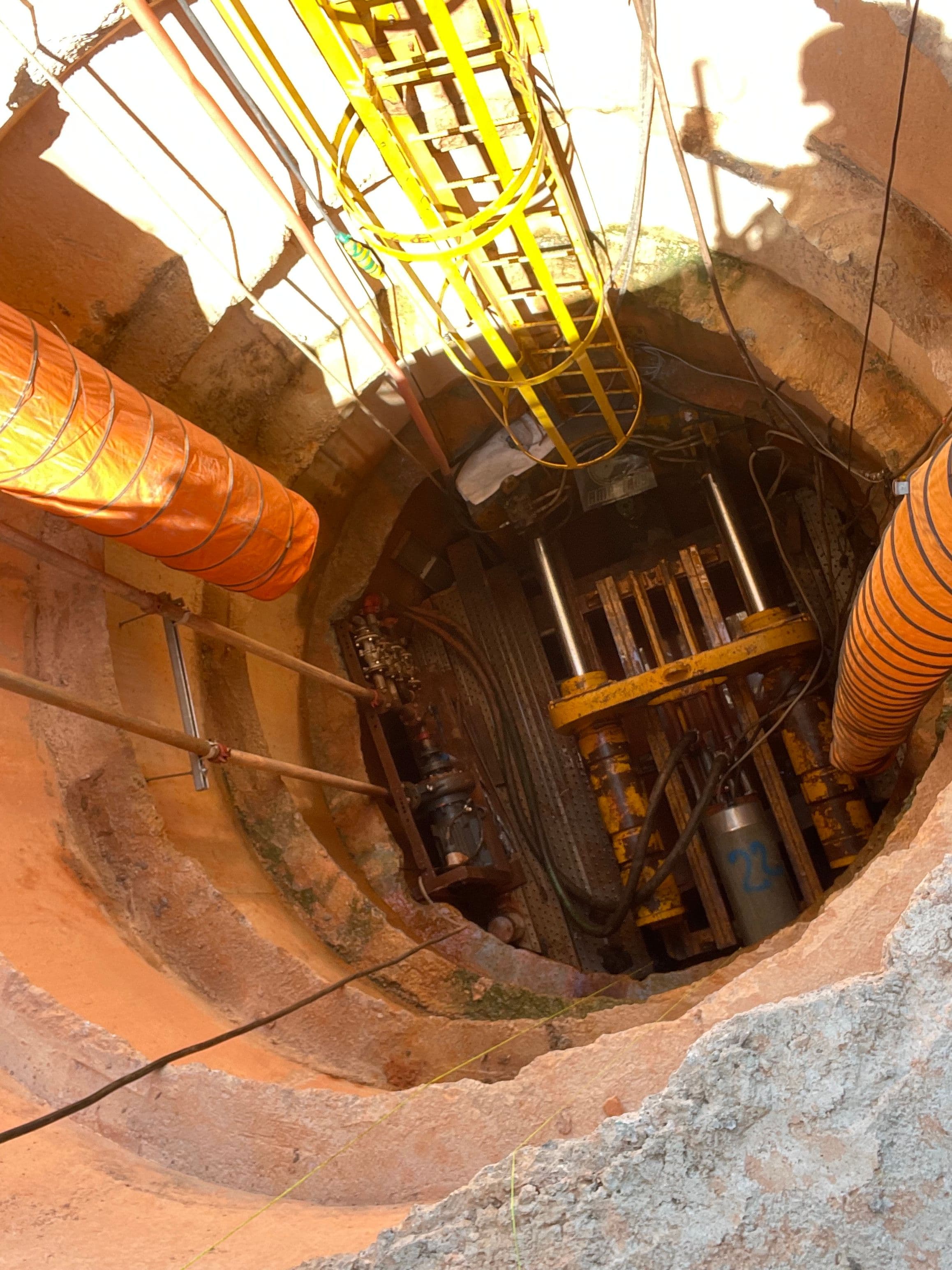 Deep pipe-jacking shaft with temporary access platforms and large ventilation ducts.